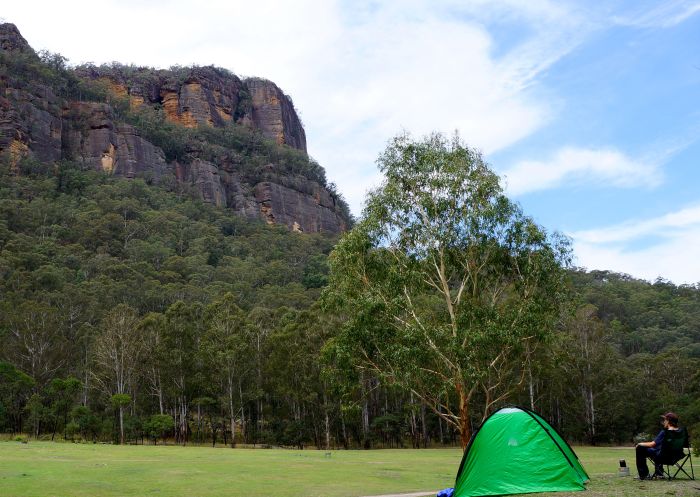 Newnes Campground, Wollemi National Park - Credit: Stephen Alton/DCCEEW Man enjoying the view with his tent pitched at Newnes Campground, Wollemi National Park