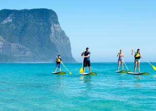 Family stand-up paddleboarding, Lord Howe Island