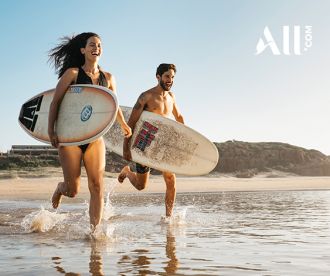 Couple going for a surf at Birubi Beach, Port Stephens