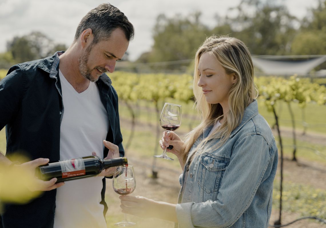 Couple enjoying a glass of wine in the vineyards of Morrisons Riverview Winery and Restaurant in Moama, Country NSW