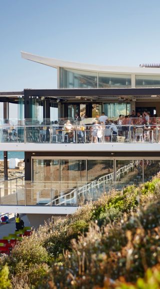 People enjoying food and drink with ocean views at Merewether Surfhouse, Newcastle